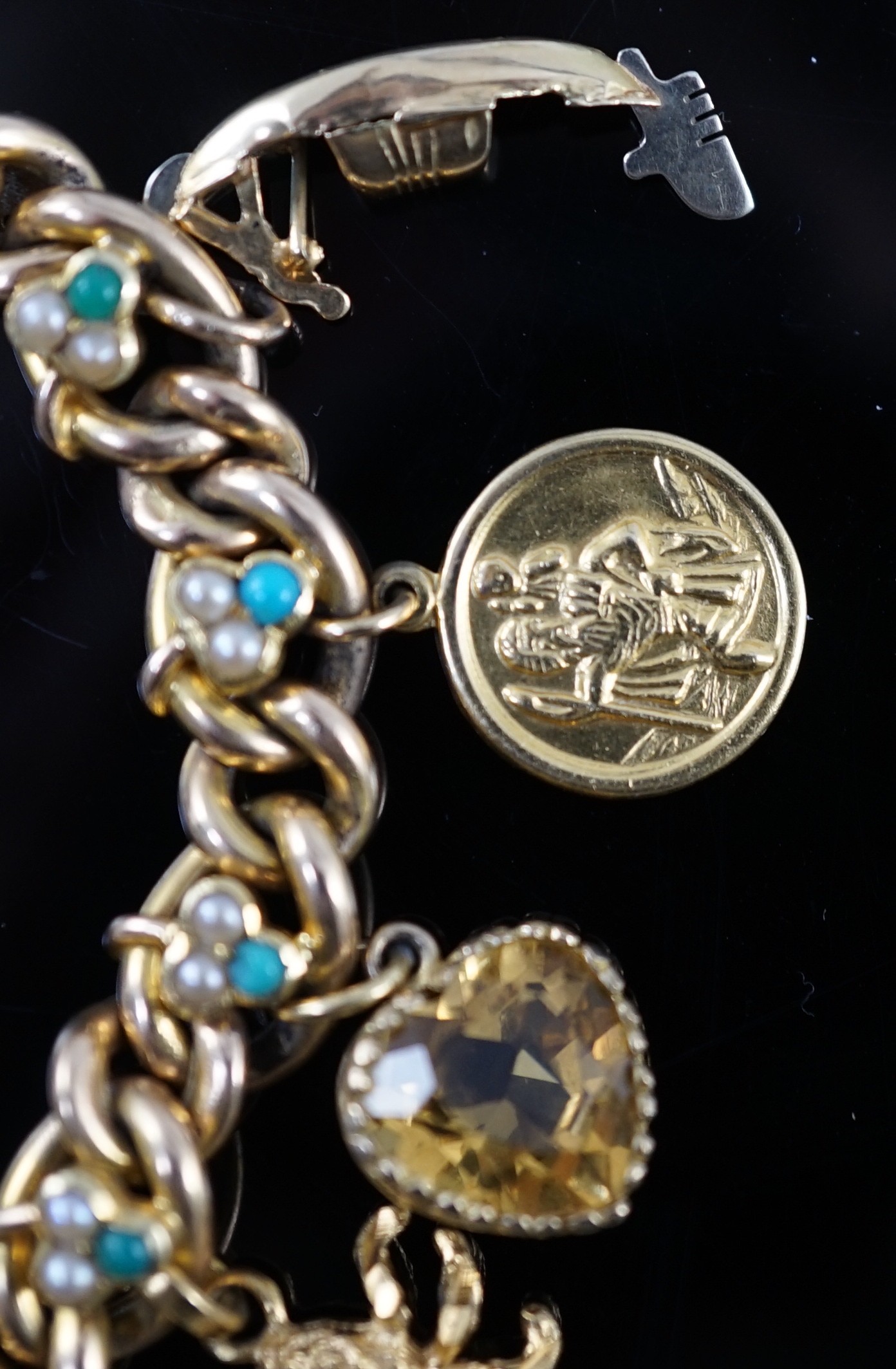 An Edwardian 15ct gold, seed pearl and turquoise set curb link charm bracelet